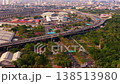 Top down aerial view of traffic flowing on a complex multi level highway interchange in Bangkok, Thailand, with urban skyline from unique perspective 138513980