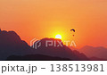Hot air balloon floating above mountain range silhouette at sunrise in Vang Vieng, Laos, scenic journey into morning sun shot from a tripod 138513981