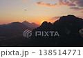 Aerial tripod view hot air balloon silhouette flying at sunrise over mountains for an adventure travel experience over nature 138514771