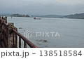 Coastal video looking out over calm bay waters from a pier with rusty railings towards distant tropical shores in the Andaman and Nicobar Islands. 138518584