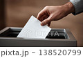Hand placing ballot in voting box 138520799