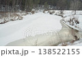 Winter creek crossing. Silent winter scene with thawing waters. Calm and chilly creek experiencing slow melting signs. Tranquil cold stream with tire marks and fragile ice along muddy riverbank 138522155