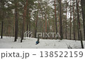 Atv airborne through snowy pine forest stunt rider launches highspeed wheelie across snowcovered clearing, vehicle becomes airborne and flips, snow spray and flying ice, towering pines and overcast 138522159