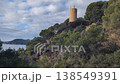 Coastal View of the Historic Torre de les Creus. This scenic location features lush greenery and a charming lookout tower overlooking the sea. A perfect retreat in nature. 138549391