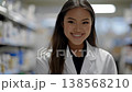 Young asian female pharmacist smiling confidently at the camera and turning away while working in a modern pharmacy. Professional healthcare worker portrait in a drugstore aisle with blurred shelves 138568210