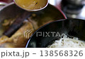 Steam Rises As Noodles Settle In Bowl. Serving Hotpot With Rising Steam And Inviting Atmosphere. Closeup Of Ladle Pouring Hot Broth Into Bowl Amid Fragrant Steam And Inviting Ambiance 138568326
