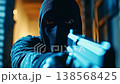 Dangerous criminal wearing a balaclava holding and pointing a gun, with his threatening eyes staring directly at the camera in a dark and moody cinematic atmosphere of suspense and danger 138568425