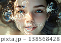 Portrait of a beautiful young woman with mesmerizing blue eyes and freckles submerged in clear water, smiling gently as sparkling bubbles and sunlight caustics play across her peaceful face 138568428