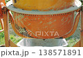 Working process of mixing concrete for the foundation of a private house, cement mortar is poured from a concrete mixer into a wheelbarrow. 138571891