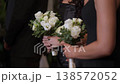 Elegant Wedding Snapshot, Detailed Shot Of Bridesmaid Grasping White Roses In Formal Wedding Setting 138572052