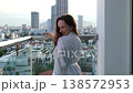 A beautiful luxury woman in a white dress enjoys the sunset view behind the modern skyline of Downtown Vietnam Danang with a drink 138572953