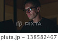 Man working late at night on laptop, illuminated by screen light and fully concentrated. Night work concentration reflects productivity, deadlines, dedication and intense modern workflow 138582467