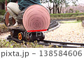A scene of children enjoying a miniature steam locomotive ride in a park, with the locomotive starting to move. 138584606