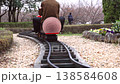 A scene of children enjoying a miniature steam locomotive ride in a park, with the locomotive starting to move. 138584608