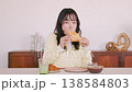 自宅で朝食のトーストを食べる若い女性 138584803
