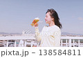 青空の下でビールを楽しむ若い女性 138584811