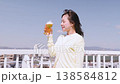 青空の下でビールを楽しむ若い女性 138584812