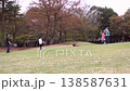 A scene of children and their families enjoying badminton and ball games on the lawn of a park surrounded by abundant nature. 138587631