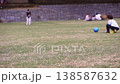 A scene of children and their families enjoying badminton and ball games on the lawn of a park surrounded by abundant nature. 138587632