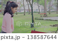 Young Girl on Rollerblades Approaching Friend on Park Bench 138587644