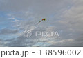Colorful kite flying in a cloudy sky. 138596002