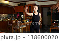 Bald middle-aged woman in black overalls dancing in home  138600020