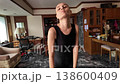 Bald middle-aged woman in black overalls dancing in home  138600409