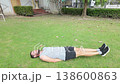 High Angle View of Athletic Bearded Man Exercising on Green Grass 138600863
