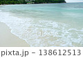 Soft sea waves wash over white sand along a tropical shoreline under calm conditions. The clip illustrates a peaceful coastal landscape, useful for travel content, beach lifestyle visuals, or tranquil 138612513