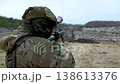 Soldier aiming and firing a handheld grenade launcher at a target during active combat.  138613376