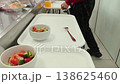 A person carrying a white tray with a fresh vegetable salad 138625460