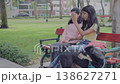 Two Teen Girls Talking on Park Bench with Dog and Rollerblades 138627271