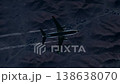 Aeroplane Banks Above Rugged Mountain Silhouette Illuminated By Green Guidance Light And Glowing Trail 138638070