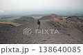 Hiker is walking towards the camera along dark volcanic hill, tourism, Sicily 4k 138640085