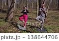 Young couple practicing yoga tree pose outdoors in the forest together 138644706