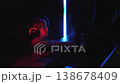 A boy wearing headphones and holding a microphone, is immersed in a game on a computer in a dimly lit room. He is seated in a comfortable leather chair. This is a state-of-the-art computer club.  138678409