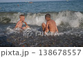 Children enjoy themselves on the beach, frolicking in the surf. The summer season is a delightful time for children. 138678557
