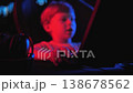 Close-up of a little boy playing a video game on a computer at night. Focus on the hand on the computer mouse. The player presses the computer mouse button. 138678562