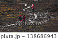 A group of hikers climbs a wet trail after rain. Climbing to the summit and overcoming difficulties 138686943