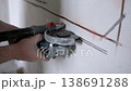 Close-up of worker using angle grinder to cut wall chases for electrical cable installation in apartment renovation. 138691288