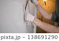 Woman Installing Electrical Cable in Wall Channel 138691290