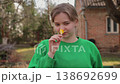 Young woman smelling a yellow flower in a garden 138692699