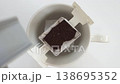 A video showing hot water being poured into a cup with a drip coffee pack inside. 138695352