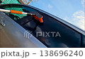 In this slow motion clip, a person uses an orange brush to wash car windows. The brush moves across the glass, showing clear reflections of the sky and clouds above. 138696240