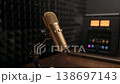 A golden microphone sits in a broadcast booth waiting for news recording late at night. 138697143