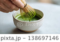 A close-up of a Japanese person's hands as they whisk matcha tea with a bamboo whisk. 138697146