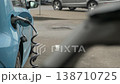 Close-up view of an EV plugged in, highlighting renewable energy trends in urban scenes. 138710725