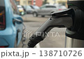 An electric car charges at a contemporary station, showcasing dynamic urban green energy trends. 138710726