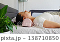 Side view of woman resting on ergonomic orthopedic pillow on bed. Calm breathing, proper neck alignment and cervical spine support for relaxation, stress relief and healthy comfortable sleep at home. 138710850