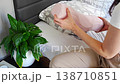 Woman holding ergonomic orthopedic pillow near bed preparing for sleep. Cervical spine support for proper neck alignment, posture correction and relief from tension, discomfort and muscle stiffness. 138710851